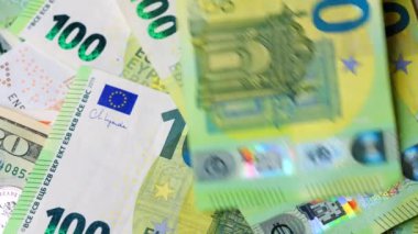 Karmaşık tasarımı ve çeşitli güvenlik özelliklerini vurgulayan 100 avroluk banknotların yakın plan ve ayrıntılı görünümü. Yavaş çekim