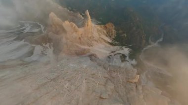 FPV İHA 'sı bulutların arasından Cristallo Dağı' nın keskin dağ uçurumlarına yakın uçuyor. İtalya ve Alplerdeki Dolomitler.