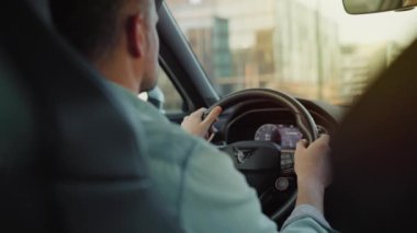Gün batımında şehrin sokaklarında araba süren adamın arka koltuğu. Yavaş çekim