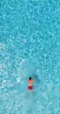 Kırmızı şortlu bir adam havuzda yüzüyor. Yaz yaşam tarzı