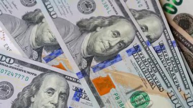 Karmaşık tasarımı ve çeşitli güvenlik özelliklerini vurgulayan 100 dolarlık banknotların yakından ve ayrıntılı görüntüsü. Yavaş çekim