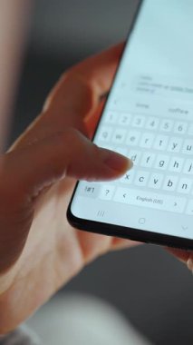 Akıllı telefondan sohbet eden, kısa mesaj yazan, dokunmatik ekran klavyesine dokunan, kurye uygulaması kullanan bir kadın. Elinde cep telefonu olan bir kadın. Dikey video