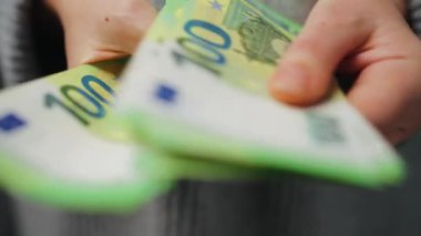 Avro banknotlarını sayan bir kadın, yakın plan. Yatırım, başarı, finansal beklentiler veya kariyer ilerlemesi kavramı.