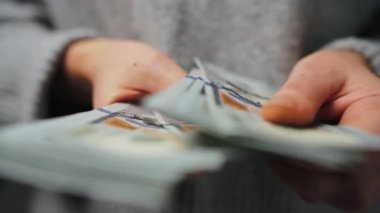 Amerikan Doları 'nı sayan bir kadın, yakın plan. Yatırım, başarı, finansal beklentiler veya kariyer ilerlemesi kavramı.