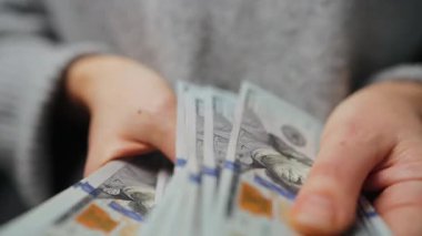 Amerikan Doları 'nı sayan bir kadın, yakın plan. Yatırım, başarı, finansal beklentiler veya kariyer ilerlemesi kavramı.