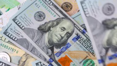 Karmaşık tasarımı ve çeşitli güvenlik özelliklerini vurgulayan 100 dolarlık banknotların yakından ve ayrıntılı görüntüsü. Yavaş çekim