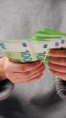 Avro banknotlarını sayan bir kadın, yakın plan. Yatırım, başarı, finansal beklentiler veya kariyer gelişimi kavramı. Dikey video