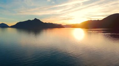 Vancouver 'ın kuzeyindeki güzel günbatımında deniz manzarası. Dağların siluetlerinin üzerine güneş batıyor. British Columbia, Kanada.