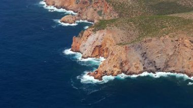 Güzel sahil manzarası, turkuaz suların üzerinde yükselen kıyı kayalıkları. Güney Sardunya, İtalya. 