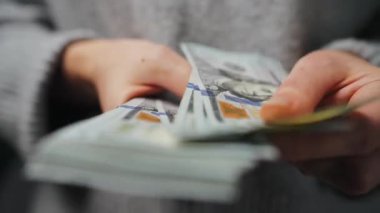 Amerikan Doları 'nı sayan bir kadın, yakın plan. Yatırım, başarı, finansal beklentiler veya kariyer ilerlemesi kavramı.