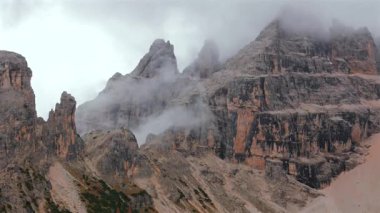 Bulutlarla kaplı yüksek sıradağların havadan görünüşü. Dolomites, İtalya 'daki Cristallo Dağı. Güzel sonbahar manzarası