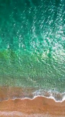 Yukarıdan aşağıya cennet kumlu plajı ve kristal berrak suyu gösteren drone görüntüsü. Rodos, Yunanistan. Dikey video