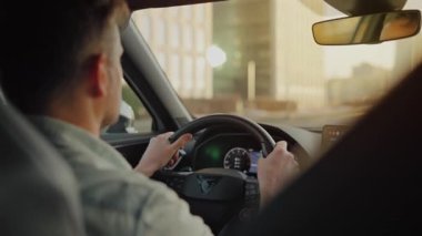 Şehrin sokaklarında araba süren bir adamın arka koltuğu.