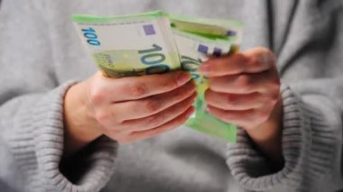 Avro banknotlarını sayan bir kadın, yakın plan. Yatırım, başarı, finansal beklentiler veya kariyer ilerlemesi kavramı.