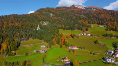 Dağ yamacındaki bir dağ köyünün havadan panoramik görüntüsü. Dolomite Dağlarında güzel bir sonbahar, İtalyan Alpleri