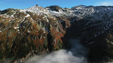 Güzel sonbahar dağ manzarası ve vadide uçan beyaz bulutlar. Alpler, Avusturya