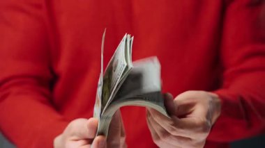 ABD Doları banknotlarını sayan adam, yakın plan. Yatırım, başarı, finansal beklentiler veya kariyer ilerlemesi kavramı.