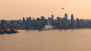 Vancouver Habour 'un ve şehir merkezindeki gökdelenlerin hava görüntüsü. Yerel bir uçak inişe hazırlanıyor. Havadaki yangınlardan çıkan duman. British Columbia, Kanada