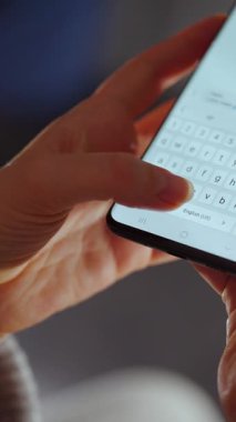 Akıllı telefondan sohbet eden, kısa mesaj yazan, dokunmatik ekran klavyesine dokunan, kurye uygulaması kullanan bir kadın. Elinde cep telefonu olan bir kadın. Dikey video