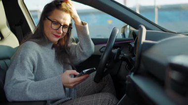 Arabada beklerken akıllı telefon kullanan mutlu güzel bir kadının portresi. Yavaş çekim