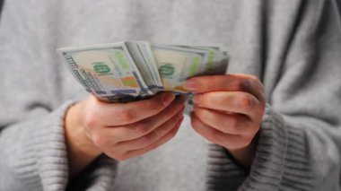 Amerikan Doları 'nı sayan bir kadın, yakın plan. Yatırım, başarı, finansal beklentiler veya kariyer ilerlemesi kavramı.