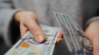 Amerikan Doları 'nı sayan bir kadın, yakın plan. Yatırım, başarı, finansal beklentiler veya kariyer gelişimi kavramı. Yavaş çekim