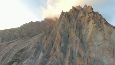 FPV İHA 'sı bulutlarla kaplı Cristallo dağının keskin tepelerine doğru uçuyor. İtalya ve Alplerdeki Dolomitler.