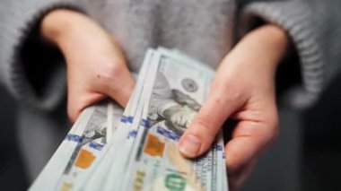 Amerikan Doları 'nı sayan bir kadın, yakın plan. Yatırım, başarı, finansal beklentiler veya kariyer gelişimi kavramı. Yavaş çekim