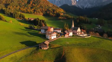 Funes Vadisi 'nin ikonik Chiesa di Santa Maddalena' yı gösteren panoramik manzarası. Arka planda, İtalyan Alplerindeki ünlü Dolomite Dağları