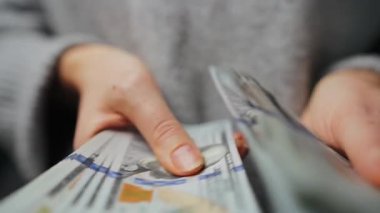 Amerikan Doları 'nı sayan bir kadın, yakın plan. Yatırım, başarı, finansal beklentiler veya kariyer gelişimi kavramı. Yavaş çekim