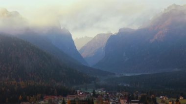 İtalyan Dolomitlerinin gizemli manzarası. İtalyan Dolomit Alpleri 'ndeki Dobbiaco kasabası yakınlarında bulutlarla kaplı dağların havadan görünüşü, Trentino Alto Adige, İtalya sonbaharda