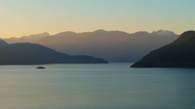 Akşamları Vancouver 'ın kuzeyindeki deniz manzarası. Mavi gökyüzü ve dağların siluetleri. British Columbia, Kanada.