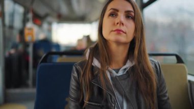 Toplu taşıma. Tramvayda akıllı telefon kullanan, arkadaşlarıyla mesajlaşan bir kadın. Şehir, şehir, ulaşım.