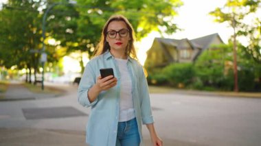 Elinde akıllı telefon olan mutlu bir kadın yaz akşamları mahallede dolanıyor. Yavaş çekim