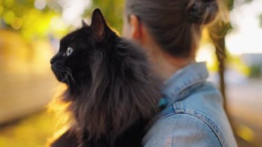 Siyah kedisini kucağına alıp kucaklayan güzel bir kadın. Kedi miyavlamaları