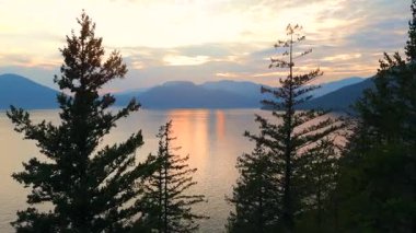 Akşamları Vancouver 'ın kuzeyindeki deniz manzarası. Gün batımı gökyüzü ve dağların siluetleri. British Columbia, Kanada.
