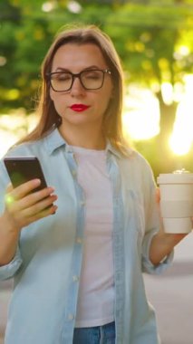 Elinde akıllı telefon olan mutlu bir kadın yaz akşamları mahallede dolanıyor. Yavaş çekim