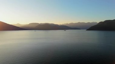 Akşamları Vancouver 'ın kuzeyindeki deniz manzarası. Mavi gökyüzü ve dağların siluetleri. British Columbia, Kanada.
