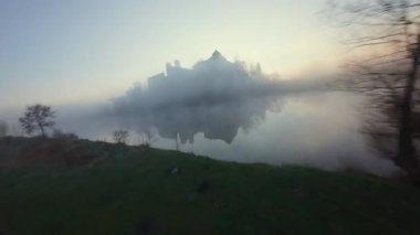 Polonya 'nın Tyniec kentindeki Vistula Nehri ve Benedictine Manastırı' nın alışılmadık hava manzarası. Güneş ışınları sabah sisinin içinden geçiyor. Katolik manastırı ve çevresindeki manzaranın eski mimarisi. Kaydedildi