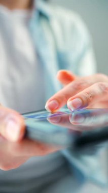 Sosyal medyada akıllı telefondan yayın yapan, dokunmatik ekranlara dokunan, kurye uygulaması kullanan bir kadın. Elinde cep telefonu olan bir kadın. Dikey video