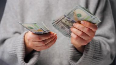 Amerikan Doları 'nı sayan bir kadın, yakın plan. Yatırım, başarı, finansal beklentiler veya kariyer ilerlemesi kavramı.