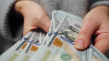 Amerikan Doları 'nı sayan bir kadın, yakın plan. Yatırım, başarı, finansal beklentiler veya kariyer ilerlemesi kavramı.