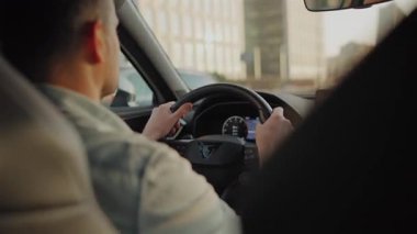 Şehrin sokaklarında araba süren bir adamın arka koltuğu..