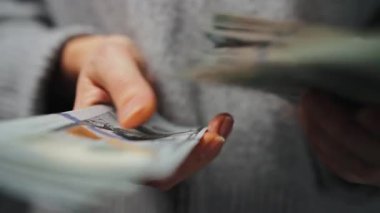 Amerikan Doları 'nı sayan bir kadın, yakın plan. Yatırım, başarı, finansal beklentiler veya kariyer gelişimi kavramı. Yavaş çekim