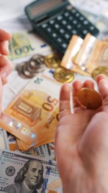 Erkek eli, BTC bitcoin 'i farklı para birimlerinin banknotları olan dolar ve avrolar ile karşılaştırır ve döndürür. Kripto para birimi kavramı ve engelleme teknolojisinin geniş dünyası..