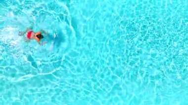 Pembe mayo giymiş bir kadının havuzda yüzüşü, ağır çekimde. Yaz yaşam tarzı.