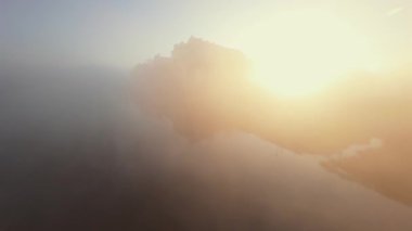 Polonya 'nın Tyniec kentindeki Vistula Nehri ve Benedictine Manastırı' nın alışılmadık hava manzarası. Güneş ışınları sabah sisinin içinden geçiyor. Katolik manastırı ve çevresindeki manzaranın eski mimarisi. Kaydedildi