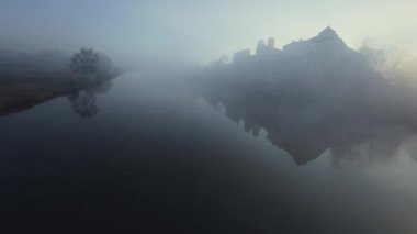 Polonya 'nın Tyniec kentindeki Vistula Nehri ve Benedictine Manastırı' nın alışılmadık hava manzarası. Güneş ışınları sabah sisinin içinden geçiyor. Katolik manastırı ve çevresindeki manzaranın eski mimarisi. Kaydedildi