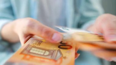 Avro banknotlarını sayan bir kadın, yakın plan. Yatırım, başarı, finansal beklentiler veya kariyer ilerlemesi kavramı.