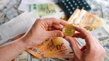 Erkek eli, farklı para birimlerinin -dolar ve avro- arka planında BTC bitcoin gösteriyor. Kripto para birimi kavramı ve engelleme teknolojisinin geniş dünyası..